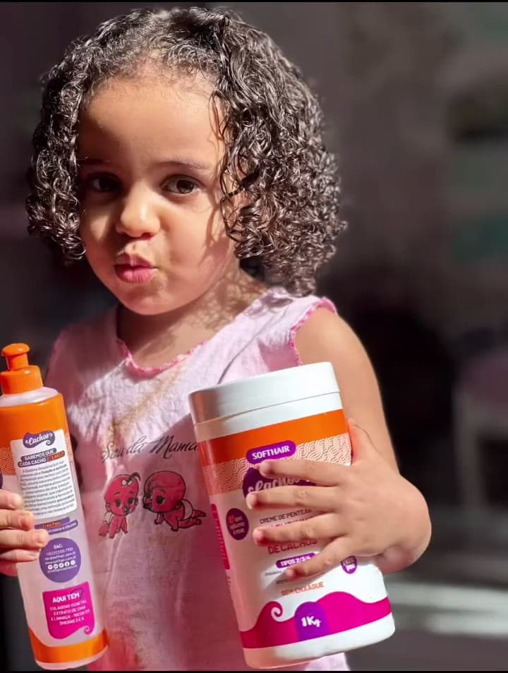 Criança de cachos com os produtos certos de cabelo infantil no salão Biia Souza, Ilha de Itaparica